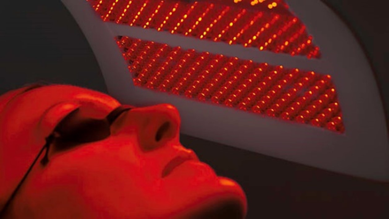 Image of someone having a Dermalux light therapy treatment, under red light
